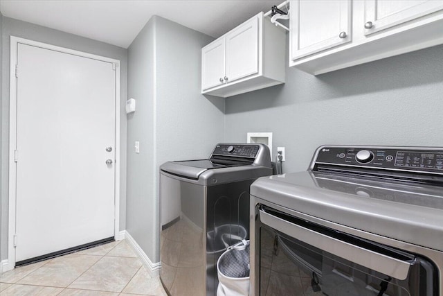 laundry room with washer and dryer, light tile patterned floors, cabinet space, and baseboards