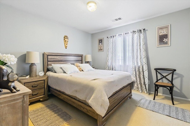 carpeted bedroom featuring visible vents and baseboards