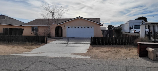 view of front of property with a fenced front yard, stucco siding, an attached garage, and concrete driveway