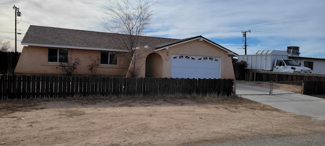 single story home with a garage, a fenced front yard, and stucco siding