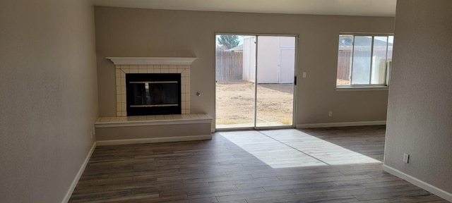 unfurnished living room with a fireplace and dark wood-type flooring