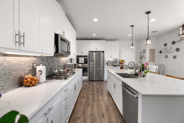 kitchen with a sink, stainless steel appliances, recessed lighting, white cabinetry, and decorative backsplash