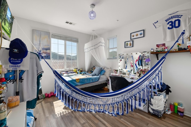 bedroom featuring visible vents and wood finished floors