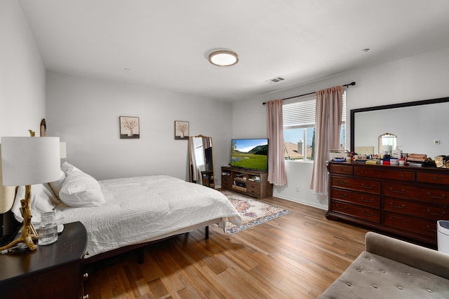 bedroom with visible vents and wood finished floors