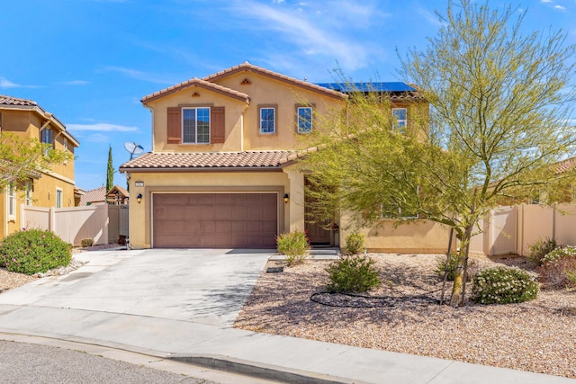 mediterranean / spanish house with an attached garage, stucco siding, a tile roof, fence, and concrete driveway