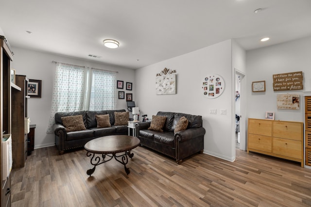 living area with recessed lighting, baseboards, visible vents, and wood finished floors