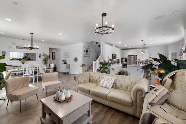 living area with stairs, a notable chandelier, dark wood-style floors, and recessed lighting