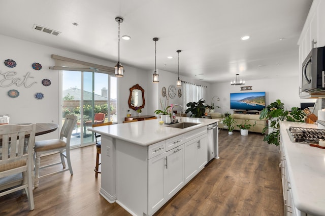 kitchen with a sink, stainless steel appliances, open floor plan, white cabinets, and visible vents