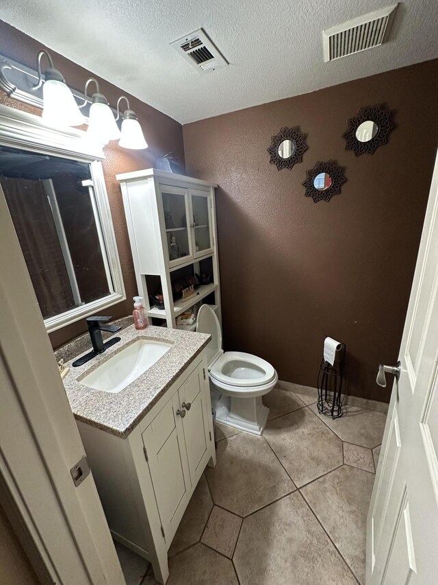 37847 Tacksteam St, Palmdale, CA 93552 - bathroom with vanity, toilet, tile patterned floors, a textured ceiling, and a textured wall