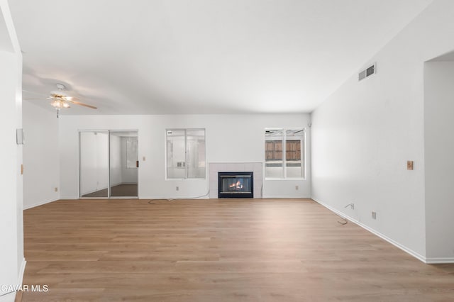 44242 Brandon Thomas Way, Lancaster, CA 93536 - unfurnished living room with ceiling fan, light wood-type flooring, and a tile fireplace