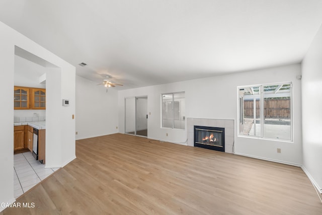 44242 Brandon Thomas Way, Lancaster, CA 93536 - unfurnished living room with light wood-type flooring, ceiling fan, and a fireplace
