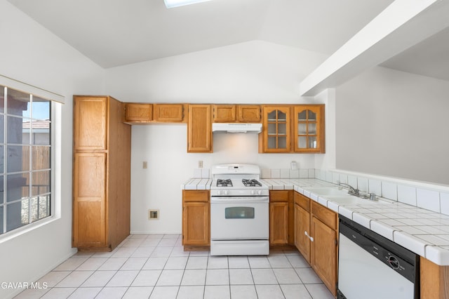 44242 Brandon Thomas Way, Lancaster, CA 93536 - kitchen with white appliances, lofted ceiling, under cabinet range hood, tile counters, and brown cabinets
