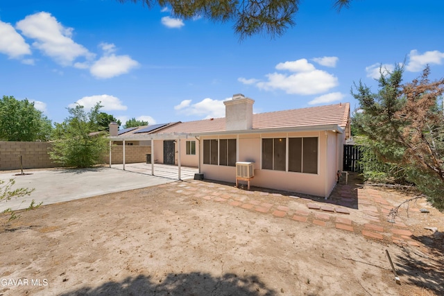44242 Brandon Thomas Way, Lancaster, CA 93536 - rear view of property featuring a patio, a chimney, solar panels, a fenced backyard, and a tiled roof
