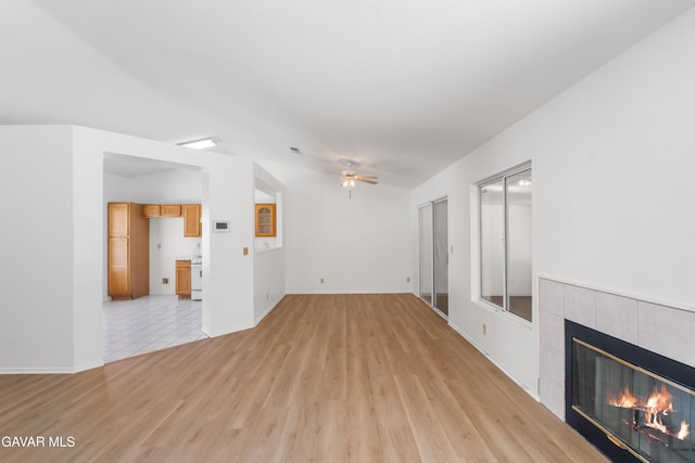 44242 Brandon Thomas Way, Lancaster, CA 93536 - unfurnished living room featuring a tiled fireplace, light wood-style floors, and a ceiling fan
