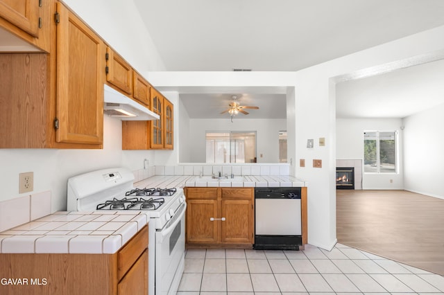 44242 Brandon Thomas Way, Lancaster, CA 93536 - kitchen featuring white appliances, under cabinet range hood, tile countertops, a fireplace, and ceiling fan