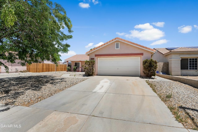 44242 Brandon Thomas Way, Lancaster, CA 93536 - view of front of house with concrete driveway, stucco siding, an attached garage, roof mounted solar panels, and a tiled roof
