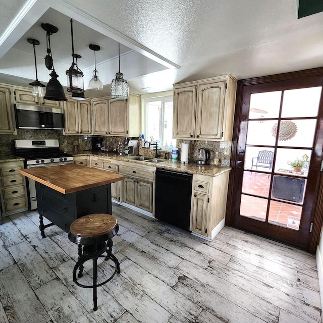 kitchen featuring hanging light fixtures, light wood-type flooring, black dishwasher, butcher block countertops, and gas stove