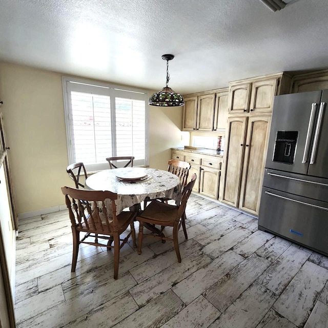 dining area featuring light hardwood / wood-style flooring and a textured ceiling