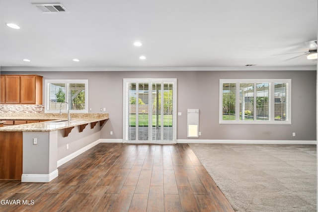 42638 Meridian Way, Lancaster, CA 93536 - kitchen featuring crown molding, light stone counters, dark wood finished floors, ceiling fan, and decorative backsplash