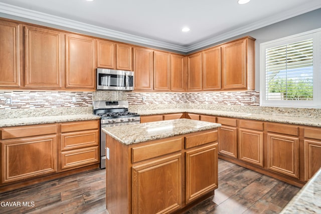 42638 Meridian Way, Lancaster, CA 93536 - kitchen featuring appliances with stainless steel finishes, dark wood-style floors, ornamental molding, light stone countertops, and tasteful backsplash