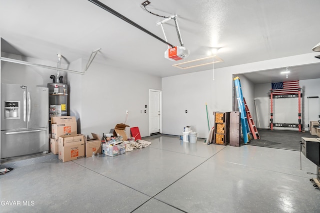 42638 Meridian Way, Lancaster, CA 93536 - garage with stainless steel fridge with ice dispenser, a garage door opener, and gas water heater