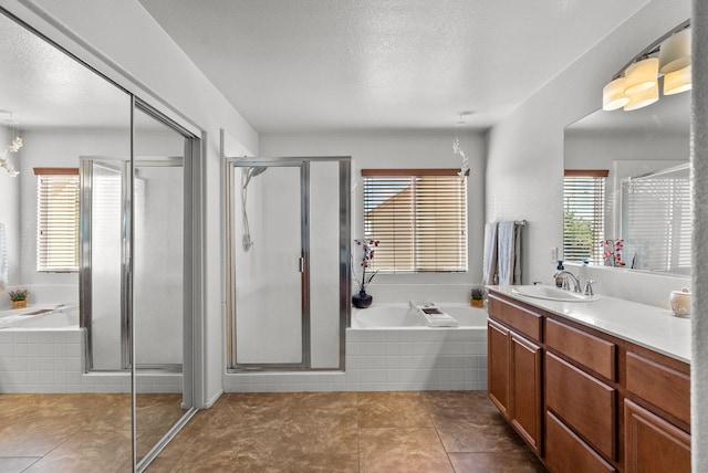 bathroom featuring tile patterned flooring, a textured ceiling, vanity, and separate shower and tub