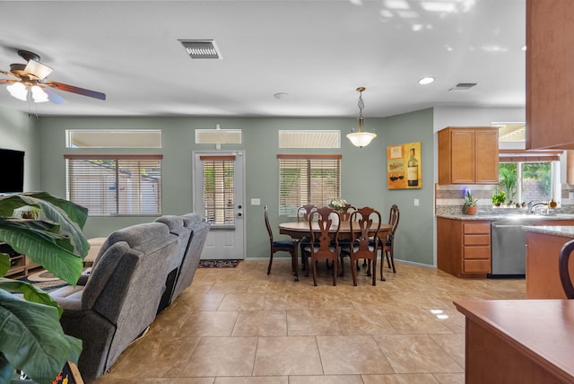 kitchen with backsplash, stainless steel dishwasher, ceiling fan, light tile patterned floors, and decorative light fixtures