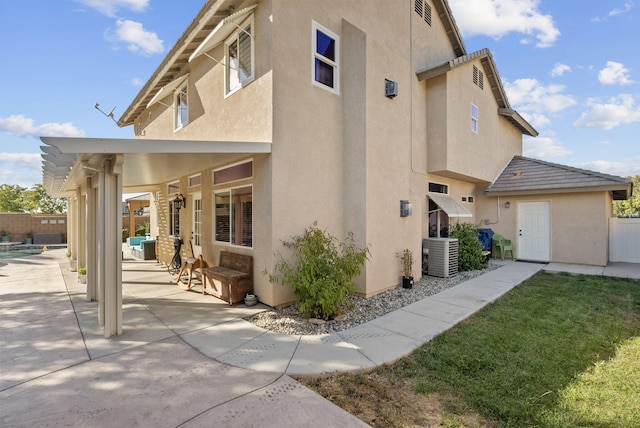 view of side of property featuring cooling unit and a patio area