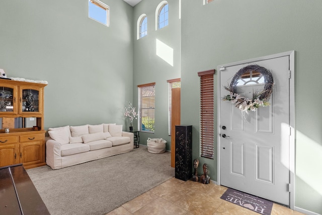 carpeted foyer featuring a high ceiling