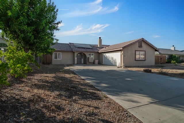 ranch-style home with solar panels and a garage