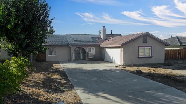 back of property with solar panels and a garage