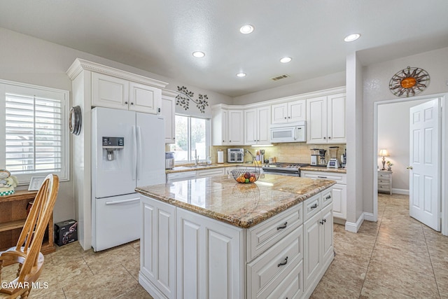 1776 Blackberry Ct, Palmdale, CA 93551 - kitchen with white appliances, a kitchen island, white cabinetry, recessed lighting, and light stone countertops