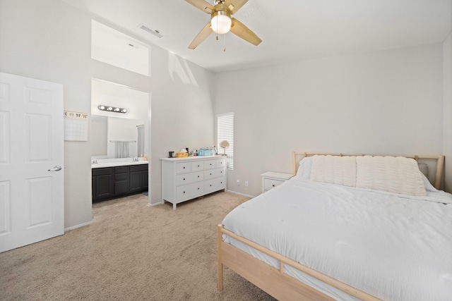 bedroom featuring connected bathroom, light colored carpet, visible vents, baseboards, and vaulted ceiling
