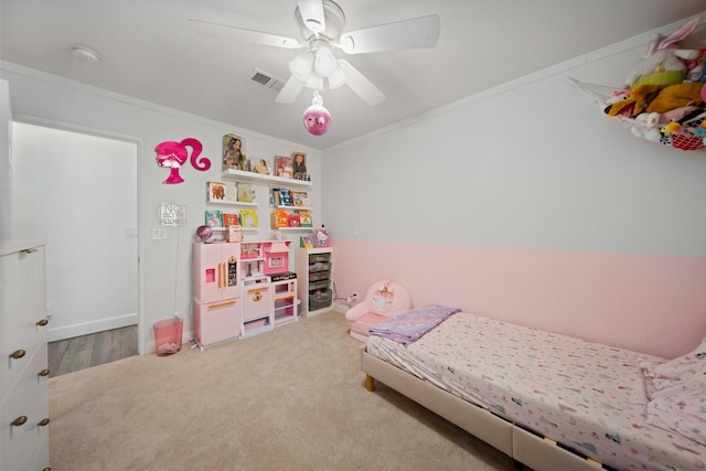 carpeted bedroom with ornamental molding, a ceiling fan, and visible vents