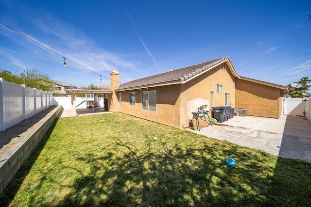 back of house featuring a patio, stucco siding, a fenced backyard, and a gate