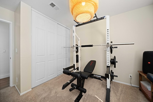 exercise room with baseboards, visible vents, and carpet