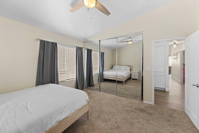 bedroom featuring ceiling fan, a closet, carpet, and vaulted ceiling