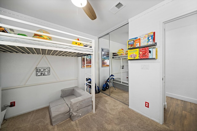 carpeted bedroom featuring a closet, visible vents, a ceiling fan, and baseboards