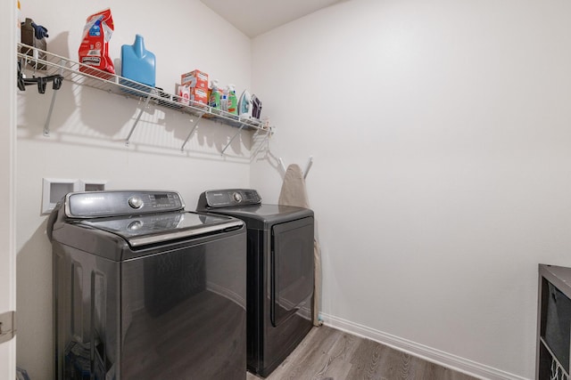 clothes washing area featuring washer and dryer and wood-type flooring