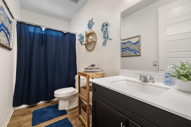 bathroom with toilet, vanity, and hardwood / wood-style flooring