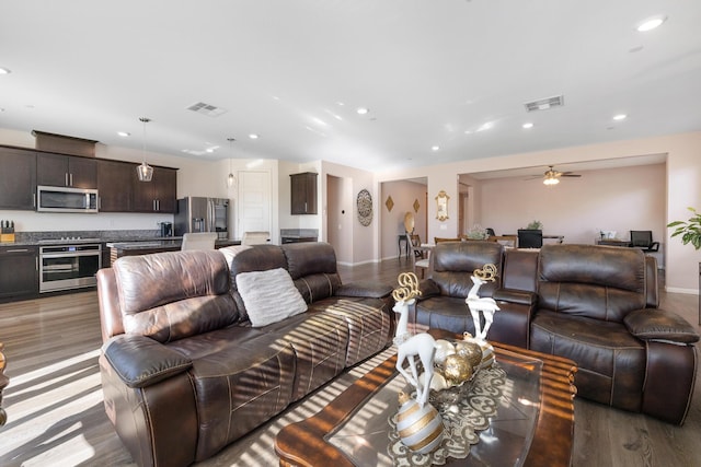 living room featuring ceiling fan and dark wood-type flooring