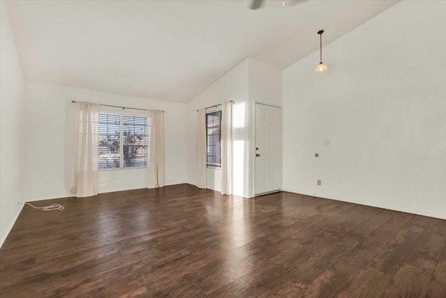 empty room featuring dark wood-type flooring and vaulted ceiling