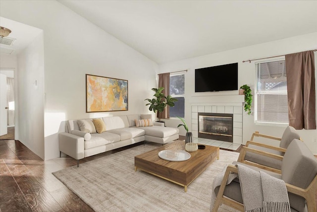 living room with hardwood / wood-style floors, vaulted ceiling, and a fireplace