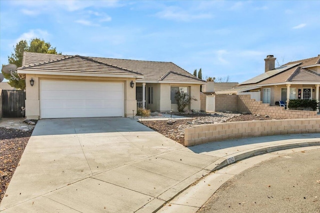 single story home with a garage and solar panels