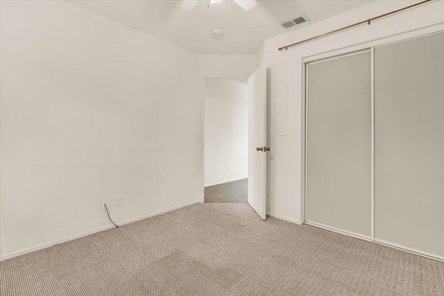 unfurnished bedroom with light colored carpet, ceiling fan, and a closet