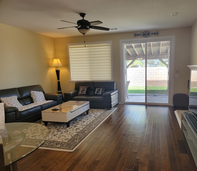 living room with dark wood-type flooring and ceiling fan