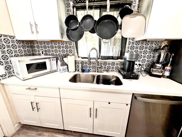43744 Beech Ave, Lancaster, CA 93534 - kitchen with white microwave, dishwasher, a sink, light countertops, and white cabinetry