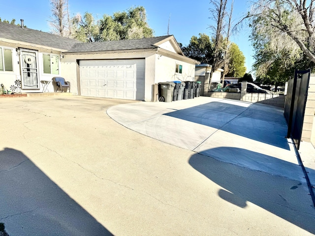 43744 Beech Ave, Lancaster, CA 93534 - view of side of home with stucco siding, driveway, a garage, roof with shingles, and a gate