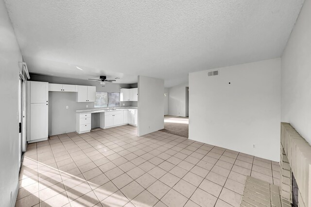 2820 S S Ave, Palmdale, CA 93550 - kitchen featuring a textured ceiling, visible vents, light countertops, a ceiling fan, and white cabinetry