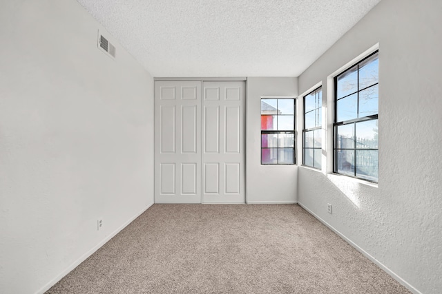 2820 S S Ave, Palmdale, CA 93550 - unfurnished bedroom with a closet, carpet floors, a textured ceiling, visible vents, and a textured wall